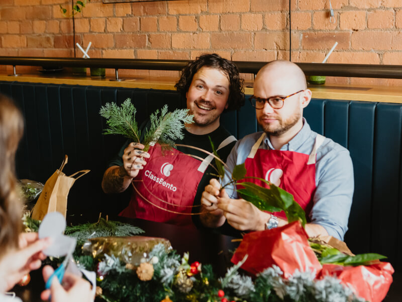 Two men enjoying a Christmas wreath making class together